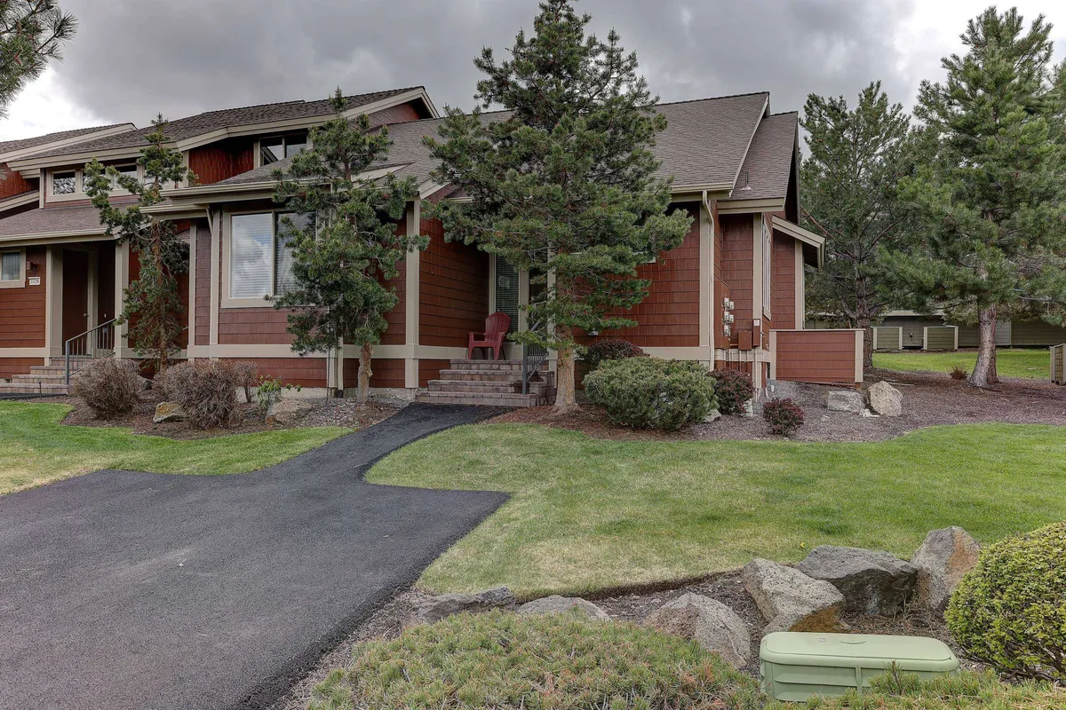 The home's inviting front porch and landscaped garden, with people relaxing and socializing at sunset. The scene features a warm, communal atmosphere, blending the privacy of home with opportunities for outdoor enjoyment.