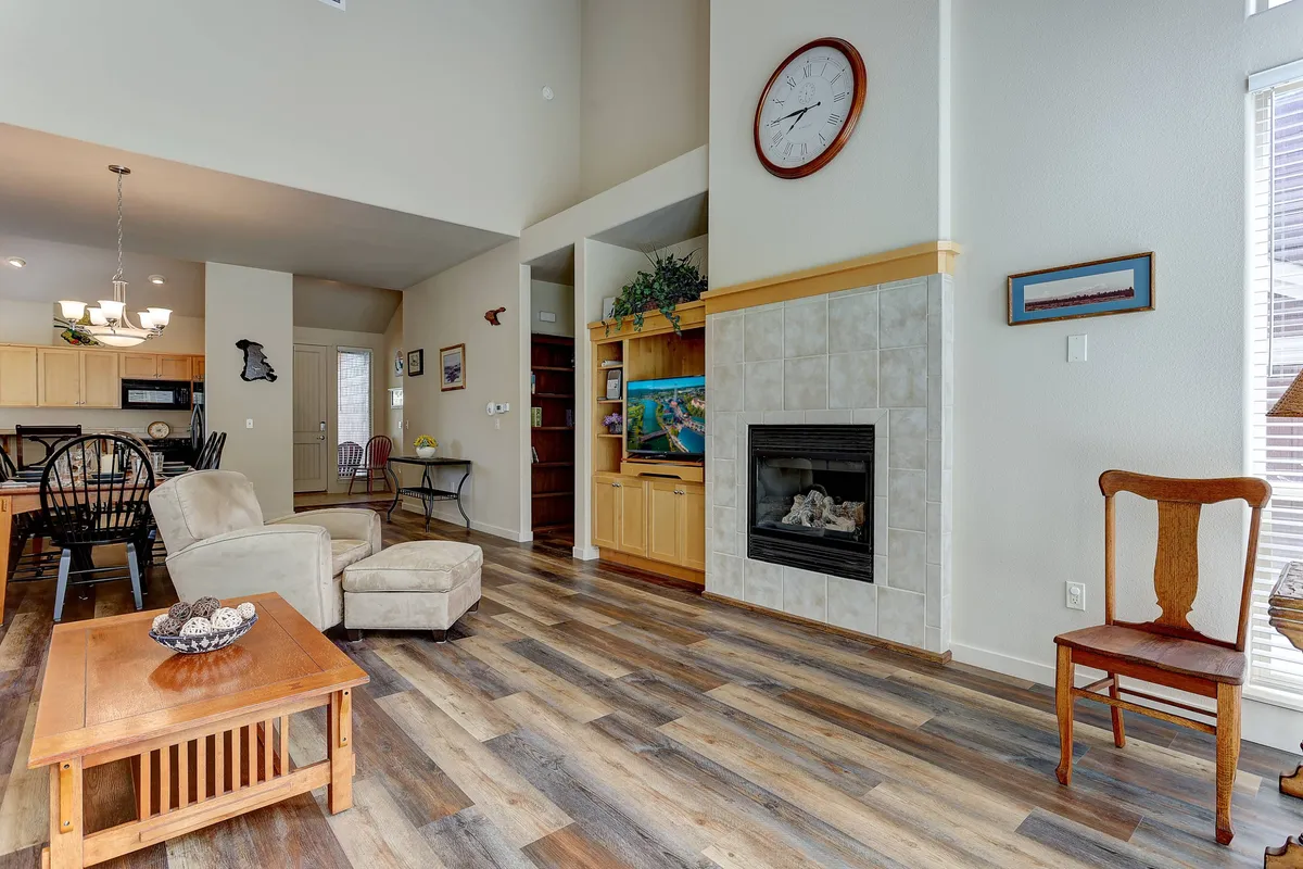 A cozy and inviting interior with a glowing fireplace, adjacent dining area, and large windows that bring in views of the outdoors. Wooden furniture and warm lighting create an intimate, relaxing atmosphere ideal for couples.